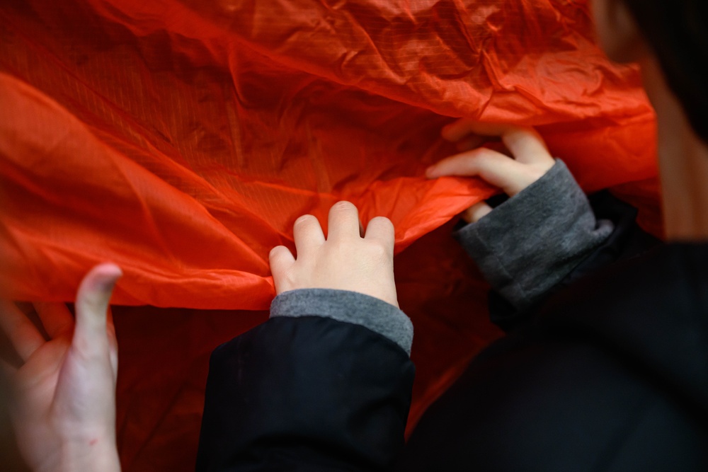 Aircrew flight equipment technicians introduce elementary students to motion, matter with parachutes