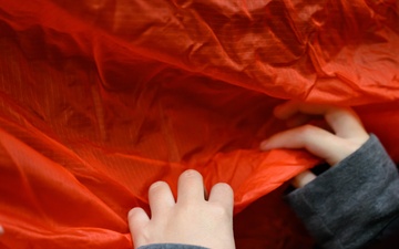Aircrew flight equipment technicians introduce elementary students to motion, matter with parachutes