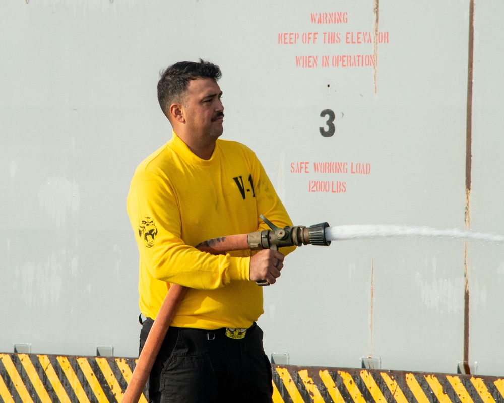 Sailors participate in a counter measure wash down.