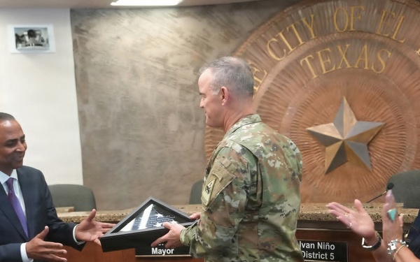 Maj. Gen. Curtis Taylor gives an American flag to the mayor of El Paso