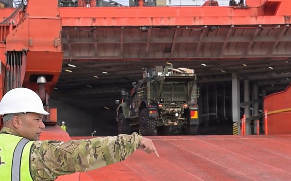 Soldier guides vehicle during offload