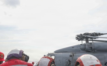 Sailors aboard the USS John Finn simulate fighting a fire during a crash and salvage drill in the Philippine Sea