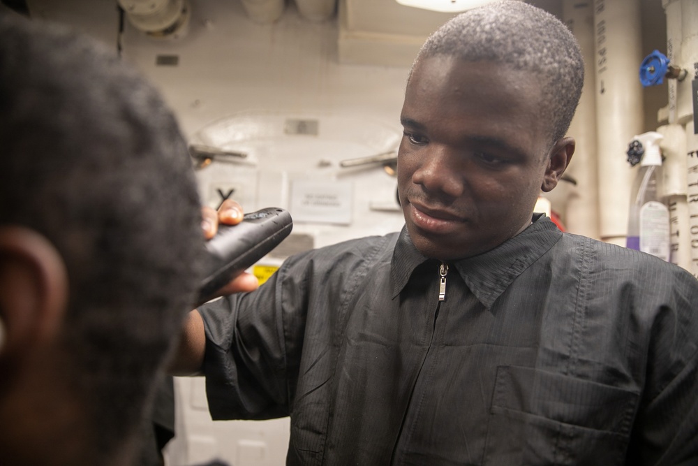 USS Mitscher (DDG 57) Sailor cuts hair in ship barbershop