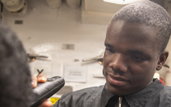 USS Mitscher (DDG 57) Sailor cuts hair in ship barbershop