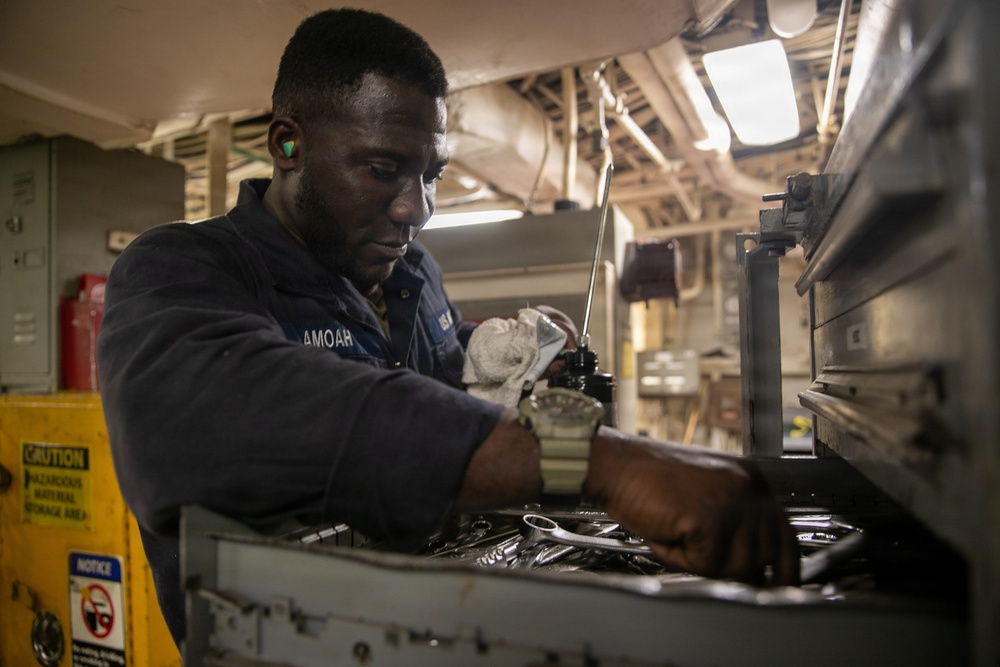 USS Mitscher (DDG 57) Sailor secures tools for maintenance in engine room