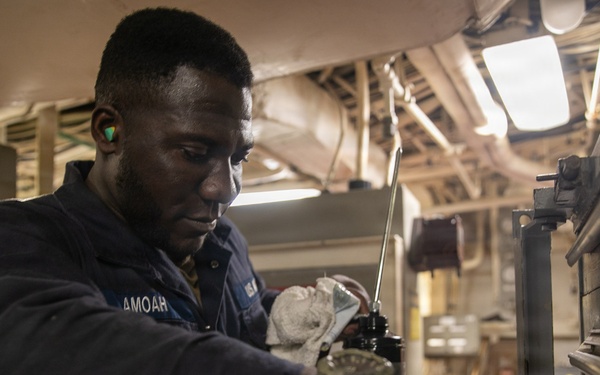 USS Mitscher (DDG 57) Sailor secures tools for maintenance in engine room
