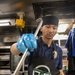 USS Mitscher (DDG 57) Sailor prepares food in ship galley