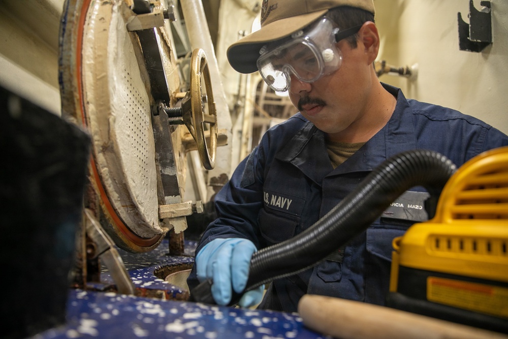 USS Mitscher (DDG 57) Sailor conducts scuttle maintenance