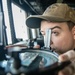 USS Mitscher (DDG 57) junior officer looks through alidade in ship bridge