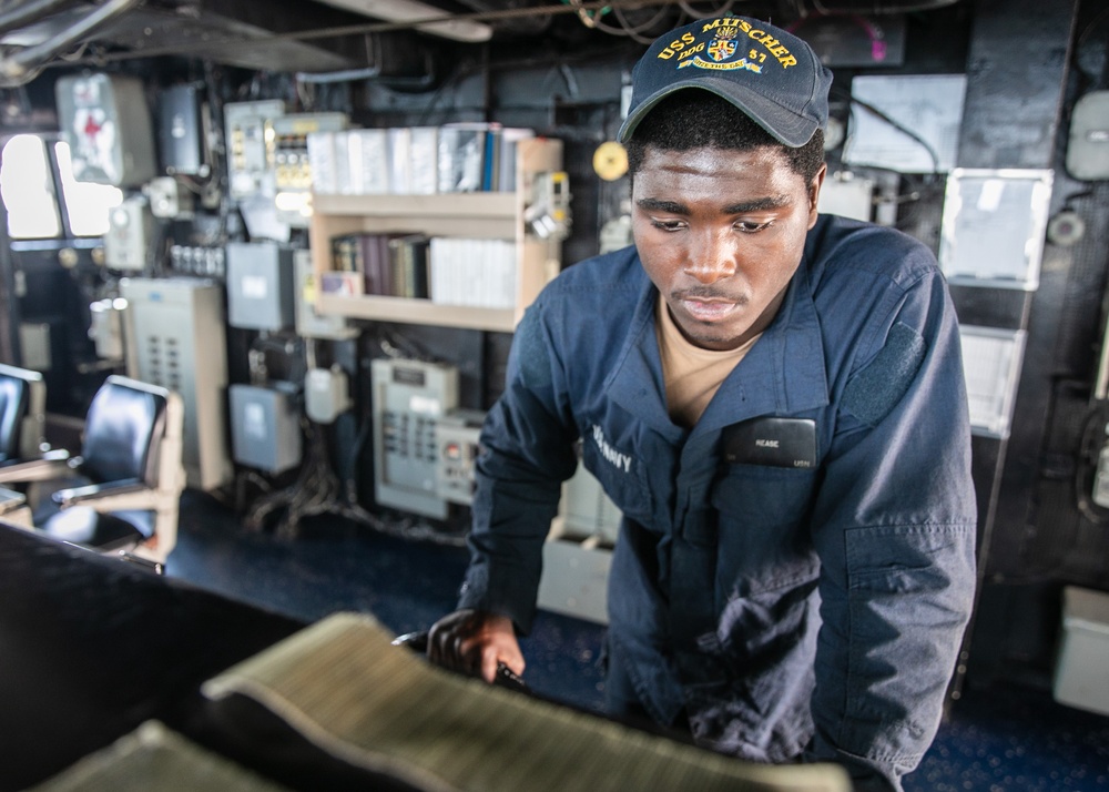 USS Mitscher (DDG 57) Sailor mans helm in ship bridge