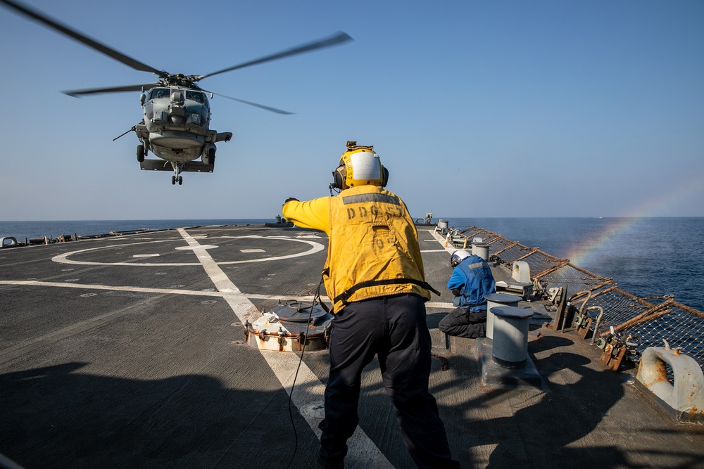 USS Mitscher (DDG 57) Sailor signals to HSM 79 Sea Hawk during flight quarters