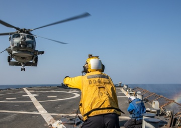 USS Mitscher (DDG 57) Sailor signals to HSM 79 Sea Hawk during flight quarters