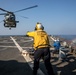 USS Mitscher (DDG 57) Sailor signals to HSM 79 Sea Hawk during flight quarters