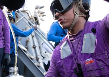 USS Mitscher (DDG 57) Sailor takes fuel sample during flight quarters