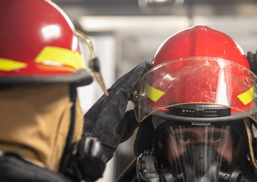 USS Mitscher (DDG 57) Sailor dons firefighting gear during GQ drill