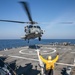 USS Mitscher (DDG 57) Sailor signals to HSM 26 Sea Hawk during flight operations