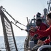 USS Mitscher (DDG 57) Sailors raise safety nets during flight quarters