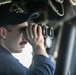 USS Mitscher (DDG 57) junior officer looks through binoculars on ship bridge