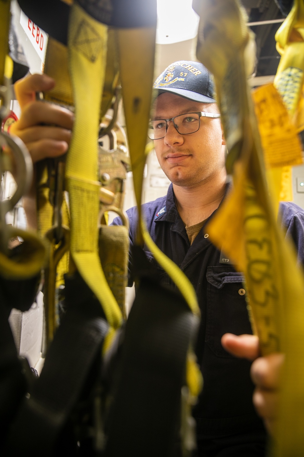 USS Mitscher (DDG 57) Sailor inspects safety harnesses in ship ET shop