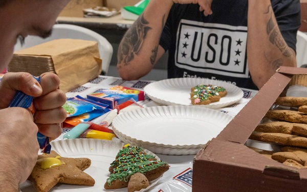 Soldiers in Latvia decorate gingerbread cookies at USO Christmas event