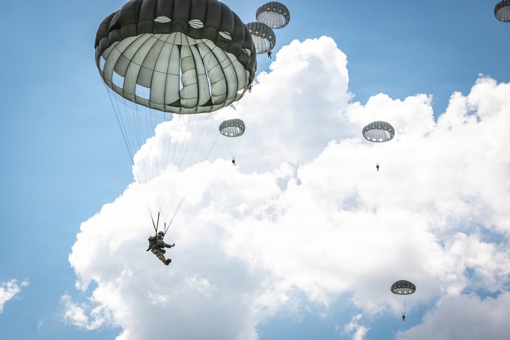 Soldiers landing after jumping from a UH-60 and conducting Airborne operation training