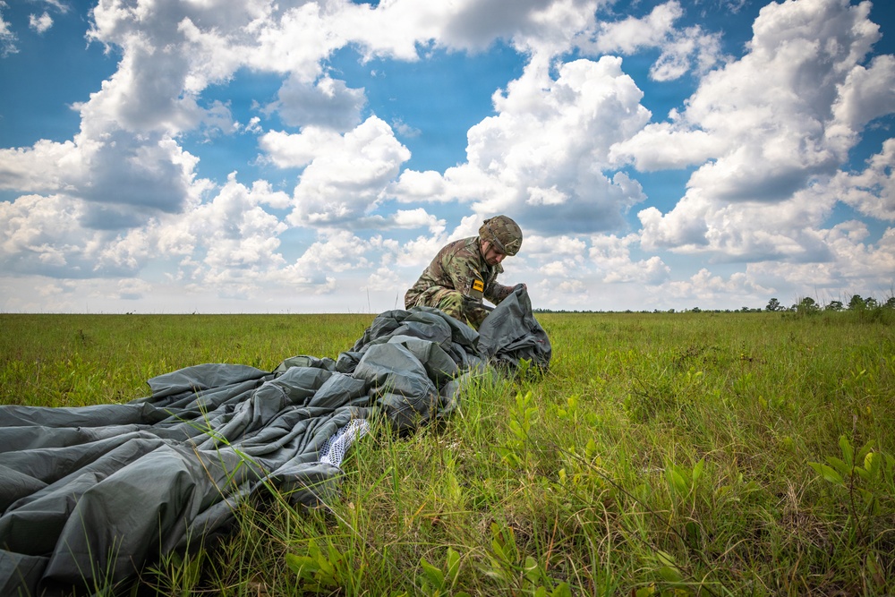 Soldier loading his parachute after jumping from a UH-60