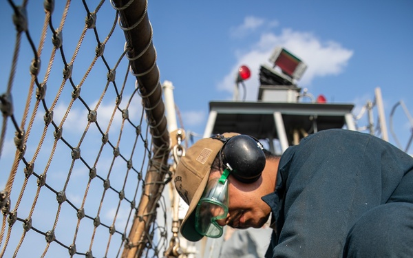 USS Mitscher (DDG 57) Sailor conducts flight deck preservation