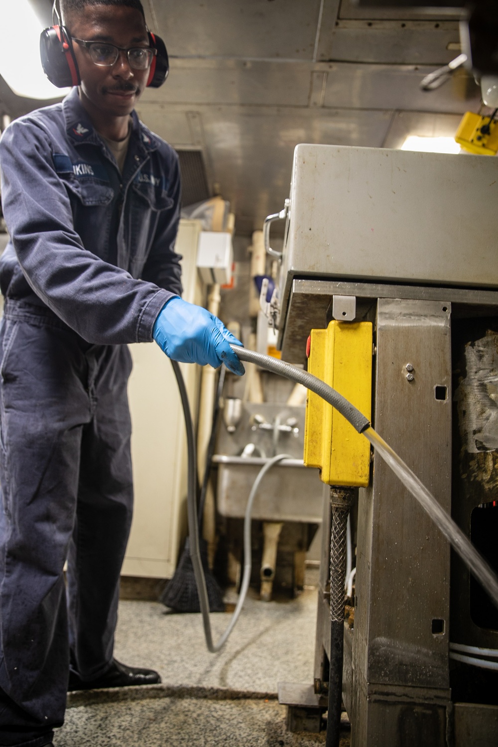 USS Mitscher (DDG 57) Sailor conducts preventative maintenance in compost disposal room