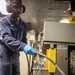USS Mitscher (DDG 57) Sailor conducts preventative maintenance in compost disposal room
