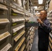 USS Mitscher (DDG 57) Sailor takes inventory in logistics storeroom