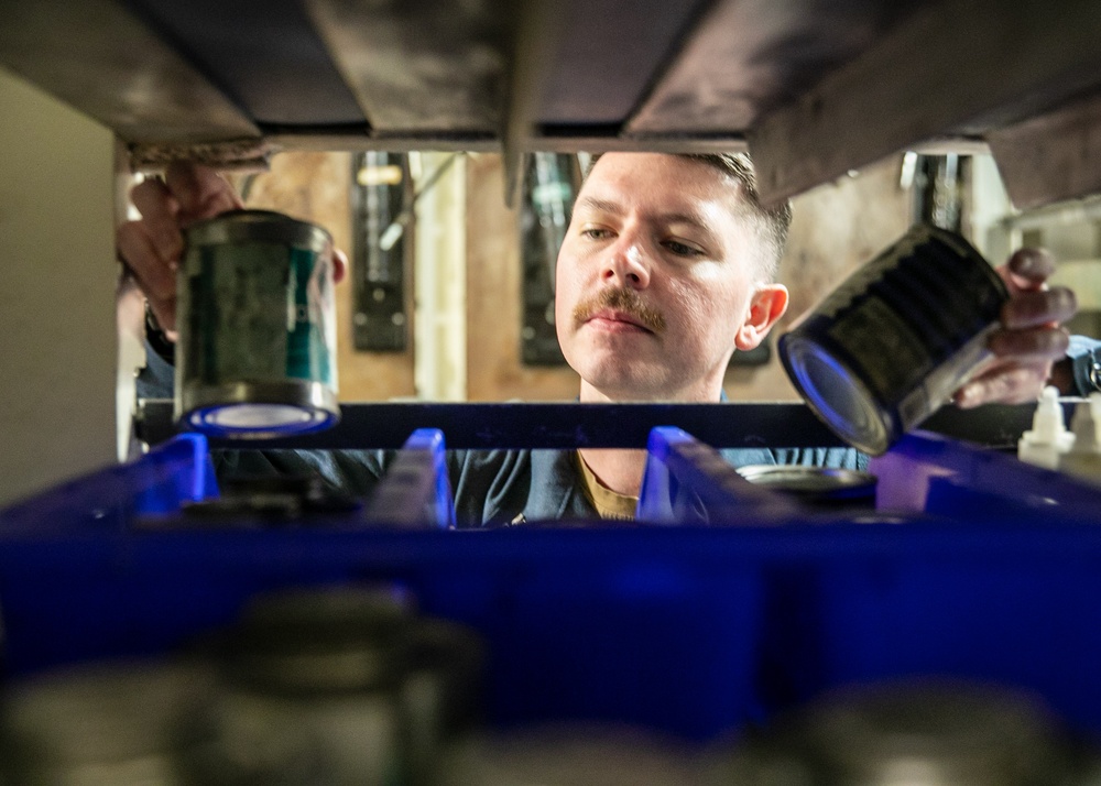 USS Mitscher (DDG 57 Sailor takes inventory in ship HAZMAT storeroom