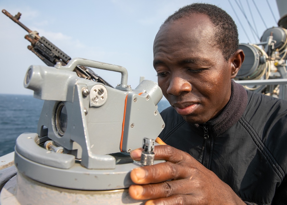 USS Mitscher (DDG 57) Sailor looks through bridge wing compass
