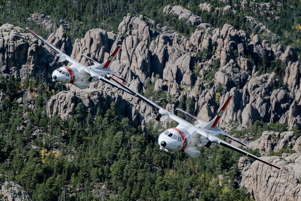 U.S. Coast Guard aircraft soar over Mount Rushmore