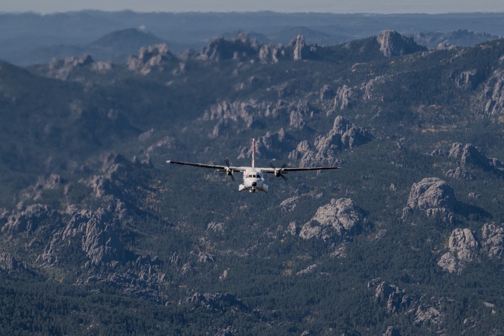 U.S. Coast Guard aircraft soar over Mount Rushmore