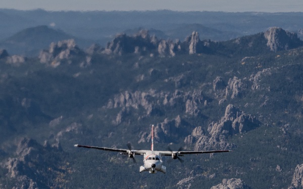 U.S. Coast Guard aircraft soar over Mount Rushmore