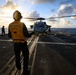U.S. Sailor Signals Sailors to Chock and Chain an MH-60R Sea Hawk Helicopter