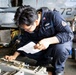 U.S. Sailor Conducts Routine Maintenance of a Rapid Securing Device in the Hangar Bay