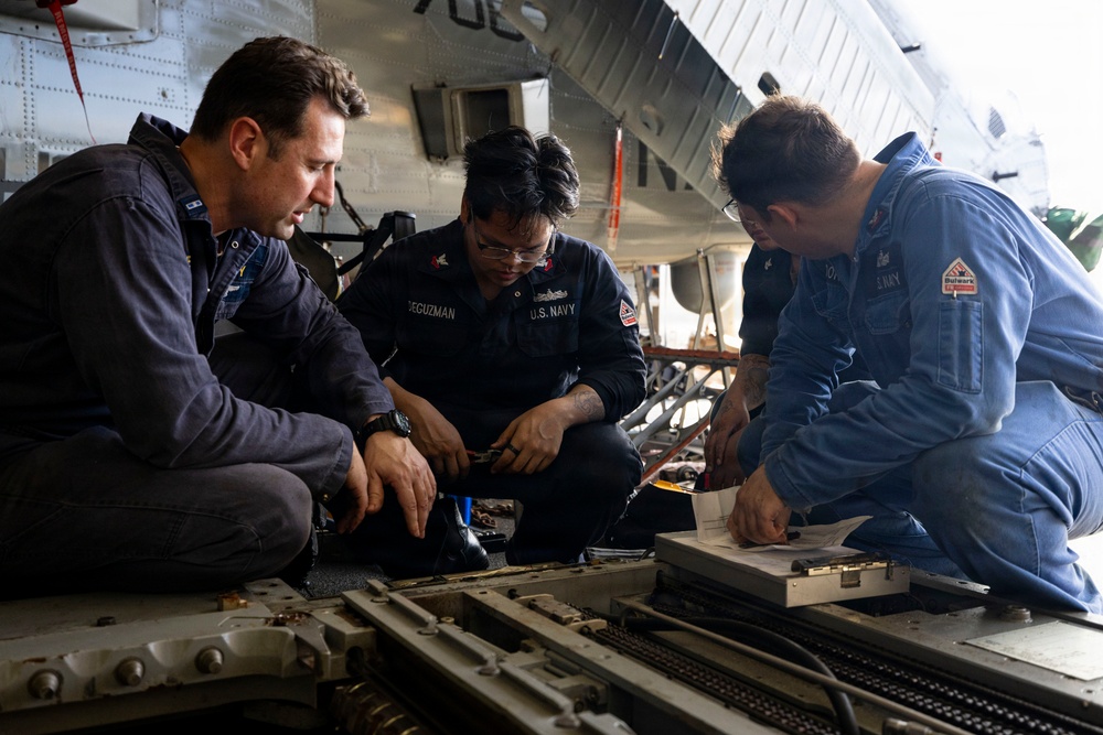 U.S. Sailors Conduct Routine Maintenance of a Rapid Securing Device in the Hangar Bay