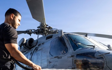 U.S. Sailor Washes an MH-60R Sea Hawk Helicopter