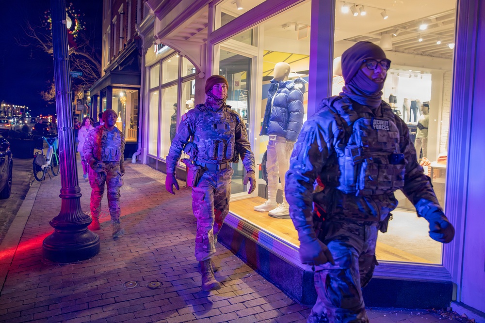 Mississippi National Guard service members walk past a store at night in Washington, D.C.