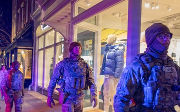 Mississippi National Guard service members walk past a store at night in Washington, D.C.