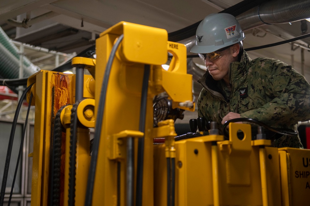 Ronald Reagan Sailors Charge Electronically Enclosed Forklift
