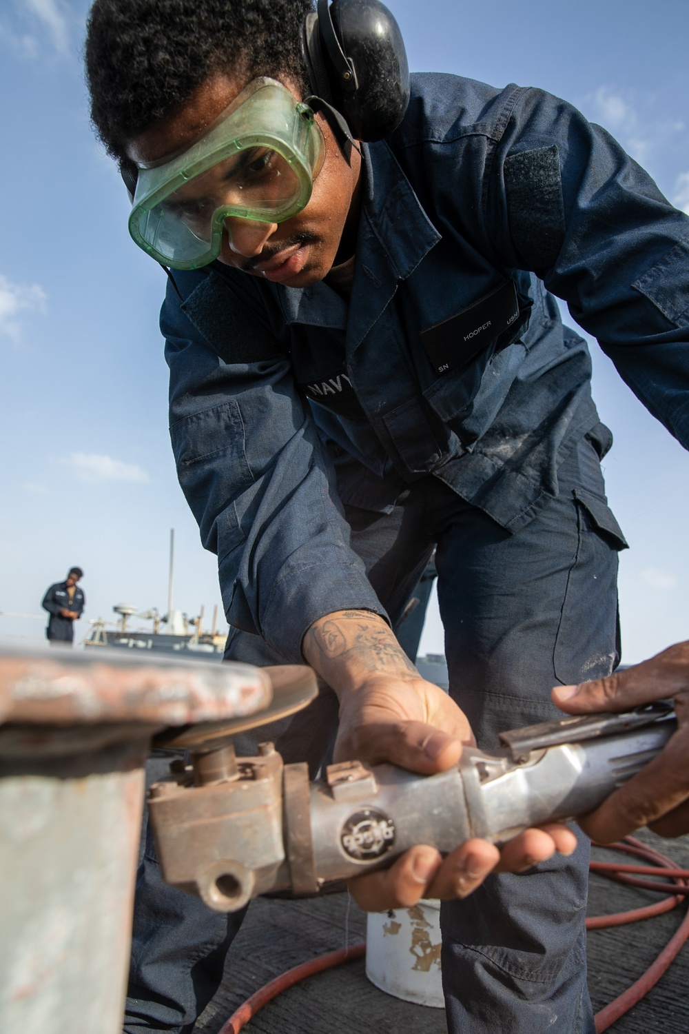 USS Mitscher (DDG 57) Sailor conducts deck preservation
