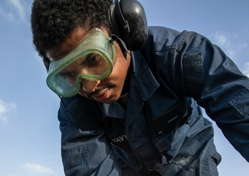 USS Mitscher (DDG 57) Sailor conducts deck preservation