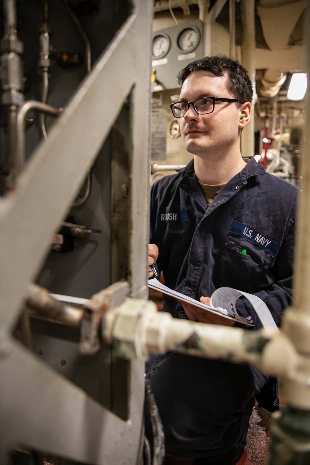 USS Mitscher (DDG 57) Sailor logs readings in engine room