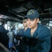USS Mitscher (DDG 57) Sailor mans the helm in ship bridge