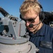 USS Mitscher (DDG 57) Sailor looks through compass on bridge wing