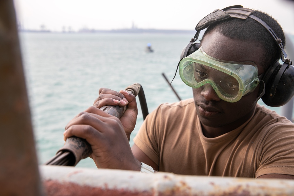 USS Mitscher (DDG 57) Sailor conducts deck preservation