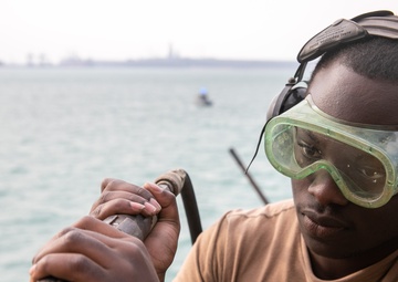USS Mitscher (DDG 57) Sailor conducts deck preservation