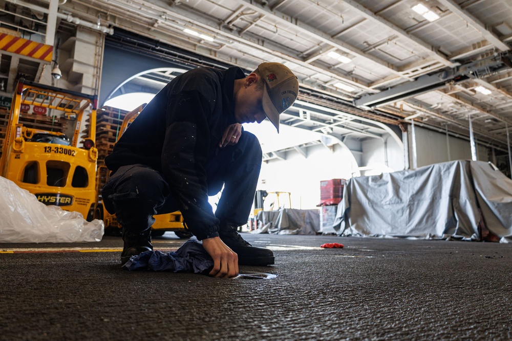 Theodore Roosevelt Sailor Cleans in Hangar Bay